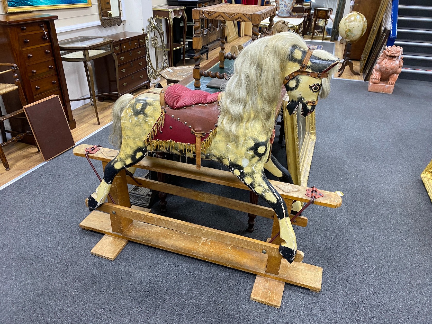 A mid 20th century Ayres type dapple rocking horse on pine safety frame height 122 cms